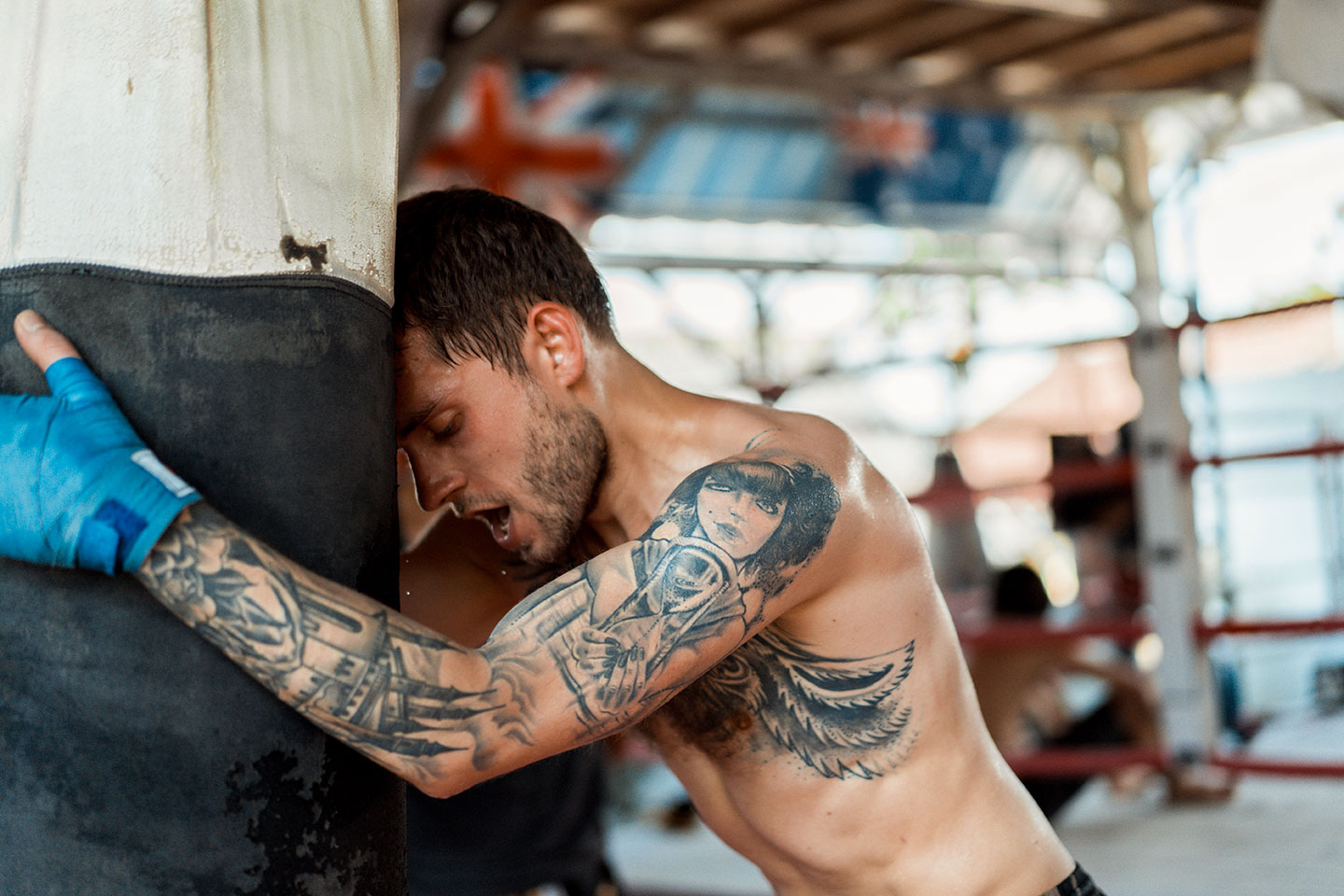 thai boxe alimentazione muay thai ragazzo con guantoni che si allena con il sacco in palestra per prepararsi a una gara