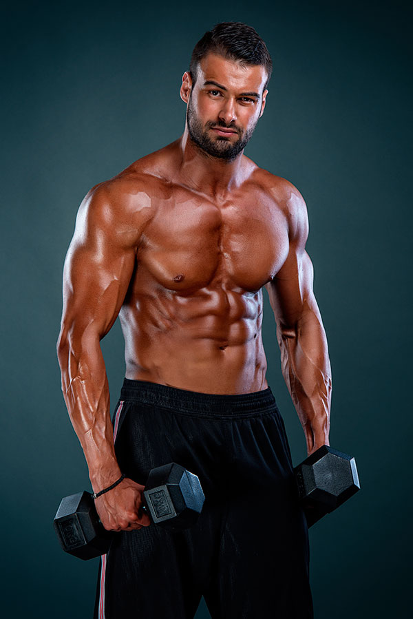 dieta per aumentare la massa muscolare, foto uomo con muscoli tesi e crescita grazie a programma alimentare del nutrizionista più integrazione di proteine