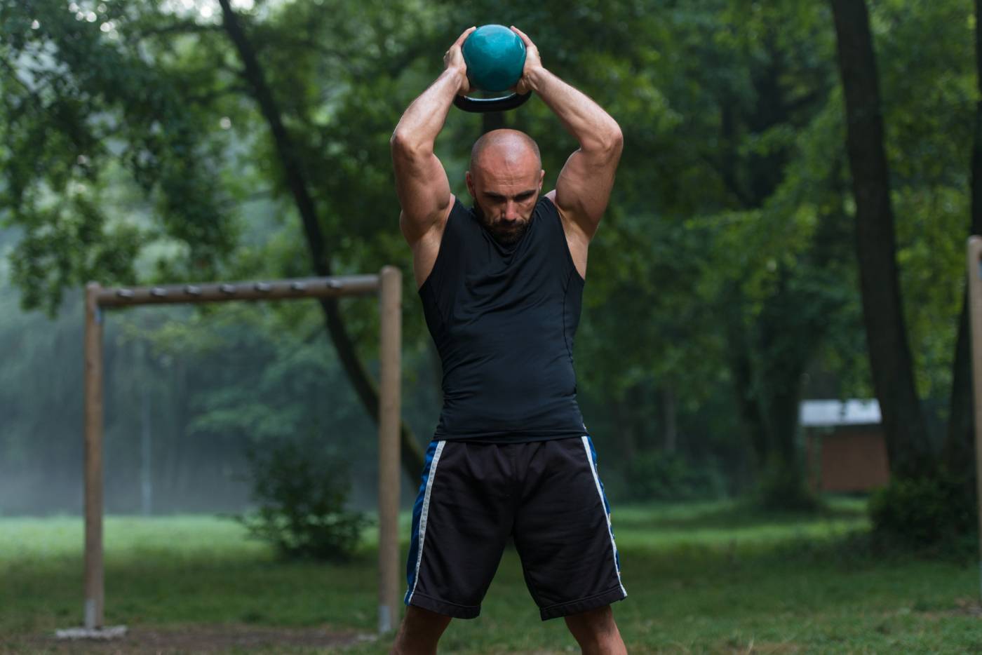 carboidrati per sportivi over 40, uomo si allena da solo al parco con un kettlebell